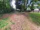 A spacious backyard featuring a wood-chipped area, trees, and a wooden fence at 2206 Rhett Ct, Lawrenceville, GA 30044