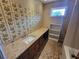Bathroom with long countertop, floral wallpaper, patterned floors, and plenty of storage space at 2206 Rhett Ct, Lawrenceville, GA 30044