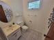 Powder room featuring a clean white sink, toilet, and white-tiled flooring at 2206 Rhett Ct, Lawrenceville, GA 30044