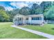 Charming single-story home with a well-maintained lawn, inviting front porch, and beautiful surrounding trees at 5160 W Chapel Hill Rd, Douglasville, GA 30135
