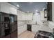 Modern kitchen featuring white cabinets, granite countertops, stainless steel appliances, and a view of the dining room at 5160 W Chapel Hill Rd, Douglasville, GA 30135