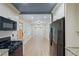 Modern kitchen featuring white cabinets, granite countertops, stainless steel appliances, and a view of the dining room at 5160 W Chapel Hill Rd, Douglasville, GA 30135