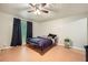 This bedroom is illuminated by a ceiling fan and natural light coming from a window at 5273 Martins Crossing Rd, Stone Mountain, GA 30088