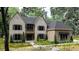 Stunning two-story home with a beautiful brick facade, dark shutters, and mature landscaping at 5743 Brendlynn Dr, Suwanee, GA 30024