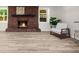 Finished basement featuring a red brick fireplace and light wood-look flooring at 1035 Hunterhill Dr, Roswell, GA 30075