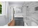 Stylish bathroom with marble tile, gray vanity, and a shower and bathtub combo at 1035 Hunterhill Dr, Roswell, GA 30075