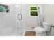 Modern bathroom features a glass shower door and window offering views of the outdoors at 1035 Hunterhill Dr, Roswell, GA 30075