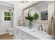 Bright bathroom with double vanity, large mirror, modern lighting and decorative plants at 1035 Hunterhill Dr, Roswell, GA 30075