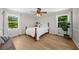 Bright bedroom with hardwood floors, white trim, and two windows for natural light at 1035 Hunterhill Dr, Roswell, GA 30075