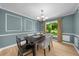 Formal dining room with modern chandelier, decorative wall panels, and natural light at 1035 Hunterhill Dr, Roswell, GA 30075