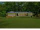 Inviting one-story house featuring a spacious lawn, complemented by lush trees for a serene setting at 1035 Hunterhill Dr, Roswell, GA 30075