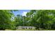 Charming single-story home with a stone accent and a well-maintained lawn surrounded by mature trees at 1035 Hunterhill Dr, Roswell, GA 30075