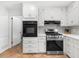 Bright kitchen featuring white cabinets, stainless steel appliances, granite countertops, and a tile backsplash at 1035 Hunterhill Dr, Roswell, GA 30075