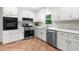 Well-lit kitchen features white cabinets, stainless steel appliances, tile backsplash, and tile flooring at 1035 Hunterhill Dr, Roswell, GA 30075