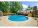 Backyard featuring a large in-ground swimming pool, complemented by a spacious deck and surrounding greenery at 1035 Hunterhill Dr, Roswell, GA 30075