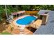 Aerial view of a private backyard oasis with a sparkling pool, wooden deck, and covered patio seating area at 1035 Hunterhill Dr, Roswell, GA 30075