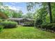 Picture of the rear exterior shows the screen porch, wooden deck and lush green backyard at 2473 Melinda Ne Dr, Atlanta, GA 30345