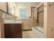 Bathroom featuring a tile floor, bathtub with a glass shower door, and brown vanity at 2473 Melinda Ne Dr, Atlanta, GA 30345