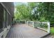 Large wooden deck with white railings, attached to the house and surrounded by lush trees at 2473 Melinda Ne Dr, Atlanta, GA 30345