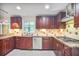 Modern kitchen featuring dark wood cabinets, granite countertops, and stainless steel appliances at 2473 Melinda Ne Dr, Atlanta, GA 30345