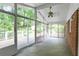 Bright sunroom features tile flooring, ceiling fan and multiple sliding glass doors to a patio and deck at 2473 Melinda Ne Dr, Atlanta, GA 30345