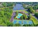 Aerial view showcasing community with a pool, tennis courts, scenic lake, and lush greenery at 2167 Merrymount Dr, Suwanee, GA 30024