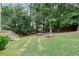 Landscaped backyard featuring a fire pit, hammock and access to upper deck at 2167 Merrymount Dr, Suwanee, GA 30024