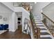 Bright foyer features hardwood floors, staircase with wooden railing, and an open view into the living room at 2167 Merrymount Dr, Suwanee, GA 30024