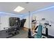 Home gym featuring weightlifting equipment, mirrored wall, hardwood floors, and blue accent lighting at 2167 Merrymount Dr, Suwanee, GA 30024