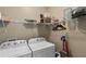 A bright laundry room with a washer, dryer, and storage shelves for convenience at 2167 Merrymount Dr, Suwanee, GA 30024
