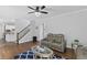 View of the living room showcasing hardwood floors, an area rug, and a comfortable gray sofa set at 2167 Merrymount Dr, Suwanee, GA 30024