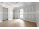 Spacious bedroom featuring new wood flooring, primed walls, arched window, and multiple doorways at 6010 Fieldcrest Dr, Morrow, GA 30260