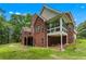 Expansive brick home featuring a screened porch, outdoor balcony, and lush green landscaping at 6020 Cochran Mill Rd, Palmetto, GA 30268