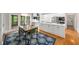 Open-concept kitchen featuring white cabinets, stainless steel appliances, and a dining table on a blue rug at 3561 Stone Dr, Marietta, GA 30062