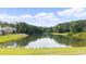 Scenic pond reflecting blue skies and framed by lush trees on a sunny day at 3561 Stone Dr, Marietta, GA 30062
