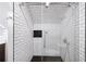 Modern shower with white subway tile, glass enclosure, and black hexagon tile floor at 3561 Stone Dr, Marietta, GA 30062