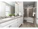 Bathroom features dual sinks, a large mirror, and a shower-tub combo with glass doors at 4810 Ivy Ridge Se Dr # 303, Atlanta, GA 30339
