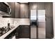 Close-up of kitchen showcasing stainless steel fridge, granite counters, and dark wooden cabinets at 4810 Ivy Ridge Se Dr # 303, Atlanta, GA 30339