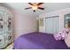 Charming bedroom with hardwood floors, a purple comforter and armoire with decorative floral design at 681 Braidwood Nw Ter, Acworth, GA 30101