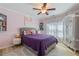 Charming bedroom with hardwood floors, a purple comforter and armoire with decorative floral design at 681 Braidwood Nw Ter, Acworth, GA 30101