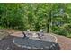 Backyard fire pit with Adirondack chairs, surrounded by lush greenery, ideal for relaxing evenings at 681 Braidwood Nw Ter, Acworth, GA 30101
