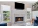 Beautiful fireplace with marble surround, flanked by two large windows and modern decor at 681 Braidwood Nw Ter, Acworth, GA 30101