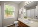 Neutral bathroom with a sink, toilet, mirror, and window with natural light at 2109 Tranquility Ct, Woodstock, GA 30188