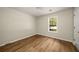 Bright bedroom with wood floors, a window, and a door to the hallway at 2109 Tranquility Ct, Woodstock, GA 30188