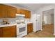 Bright kitchen with wooden cabinetry, white appliances, and durable wood flooring at 2109 Tranquility Ct, Woodstock, GA 30188