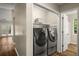 Laundry area with modern washer and dryer, wood floors, and convenient shelving at 2109 Tranquility Ct, Woodstock, GA 30188