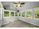 Inviting sunroom featuring a ceiling fan, neutral paint, and multiple windows offering views of the landscape at 2109 Tranquility Ct, Woodstock, GA 30188