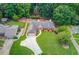 Aerial view of a well-maintained home with lush landscaping, long driveway, and backyard wooded area at 3550 Miller Farms Ln, Peachtree Corners, GA 30096