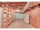 Unfinished basement area with overhead pipes, wooden shelving, and storage space at 3550 Miller Farms Ln, Peachtree Corners, GA 30096