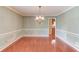 Dining room featuring hardwood floors, wainscoting, and modern lighting, with view to the kitchen at 3550 Miller Farms Ln, Peachtree Corners, GA 30096